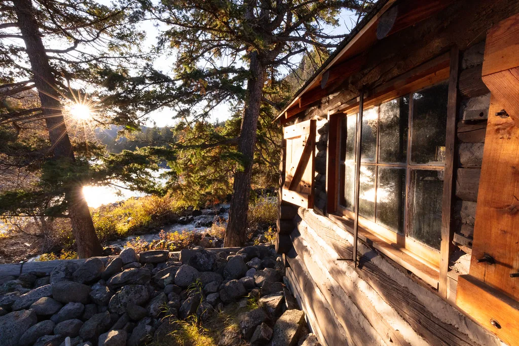 Sunrise seen from the cabin porch past log walls
