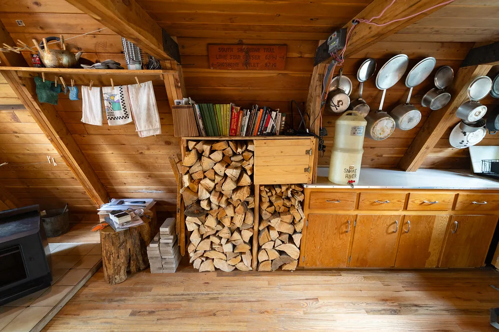 Kitchen counter with a firewood cubby, bookshelf and hanging pans