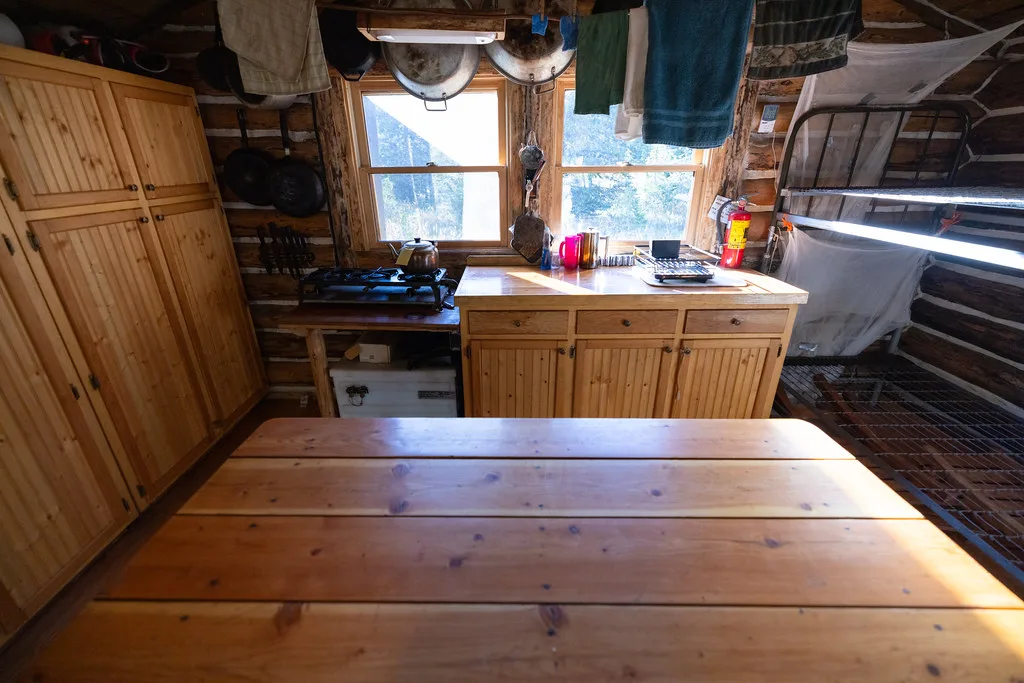 Plank dining table in front of a kitchen counter and cabinets